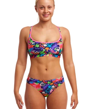 Sportbikini, Funkita Sharp Edge, färgglatt abstrakt mönster, tunna band, för kvinnor. En kvinna står framifrån med avslappnade armar.